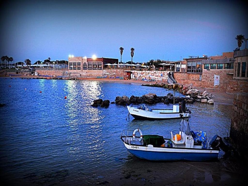 dos barcos están atracados en un cuerpo de agua en Caesarea Vacation Rooms, en Cesarea