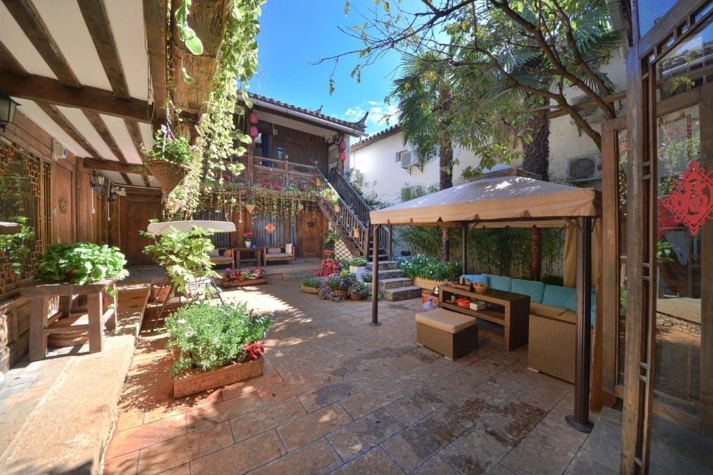 an outdoor patio with a table and an umbrella at Lewo Guest House in Lijiang