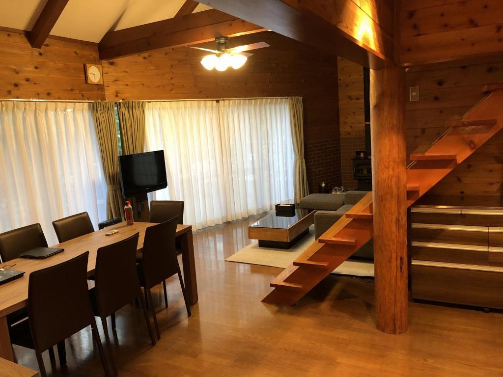忍野村的住宿－スイートヴィラ山中湖，客厅设有楼梯和桌椅