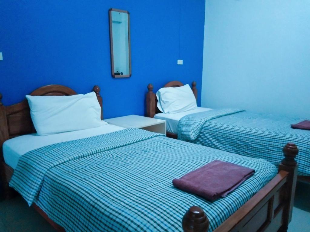 2 camas en una habitación con paredes azules en Kasarin Court, en Fang