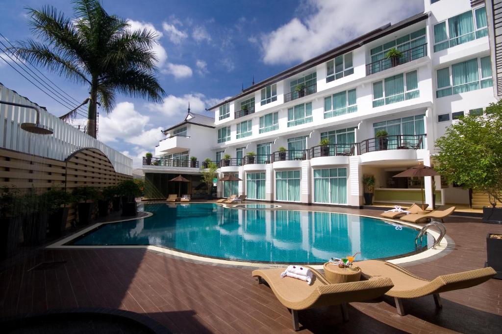 a swimming pool in front of a building at A-Te Chumphon Hotel - SHA Plus in Chumphon