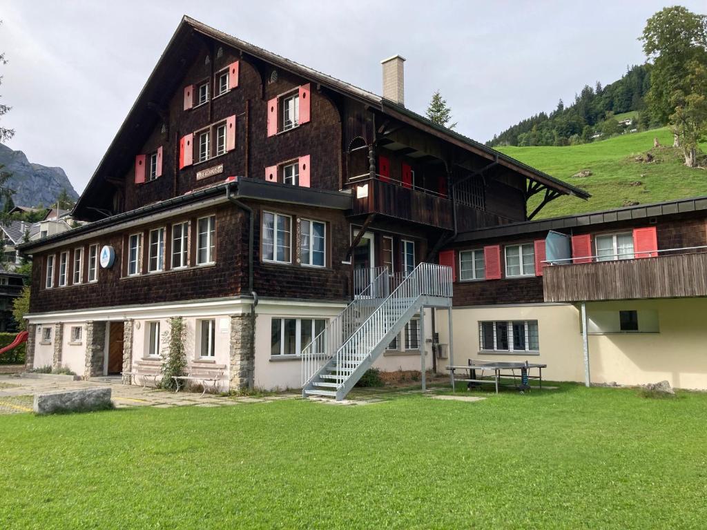 uma casa grande com uma escada em frente em Engelberg Youth Hostel em Engelberg