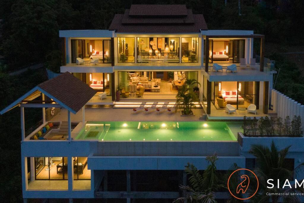 a large house with a swimming pool at night at Jungle Beach Villa in Amphoe Koksamui
