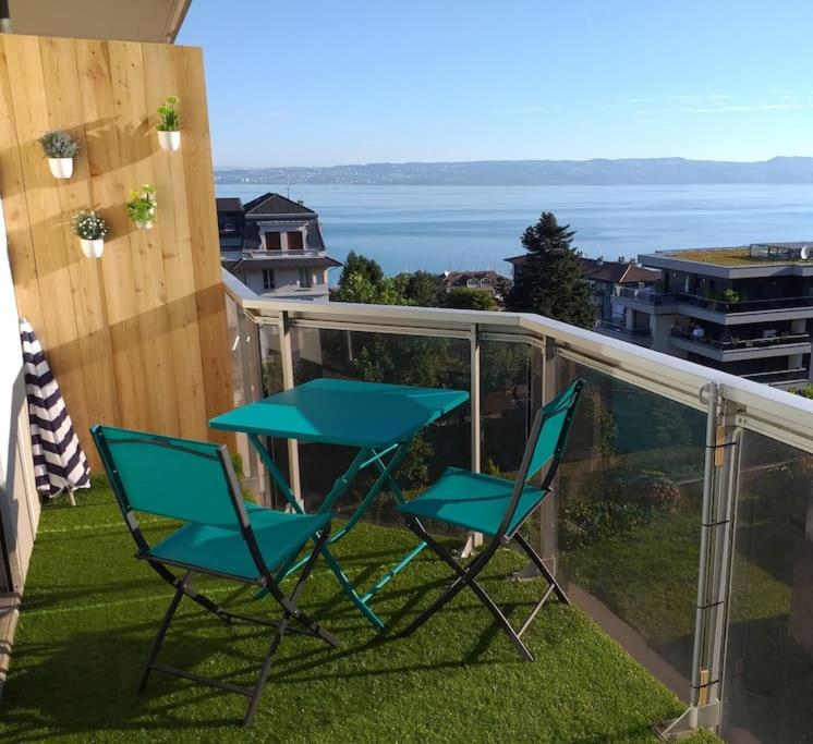 two chairs and a table on a balcony at Entre Lac et Montagne in Évian-les-Bains