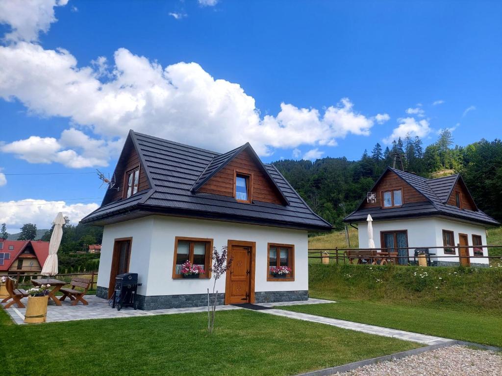 uma casa com um telhado preto e uma mesa de piquenique em Domek u Kozika em Krościenko