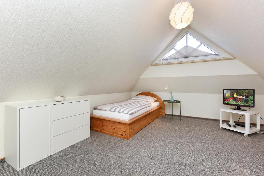 een slaapkamer op zolder met een bed en een raam bij Haus Strandlooper in Neuharlingersiel
