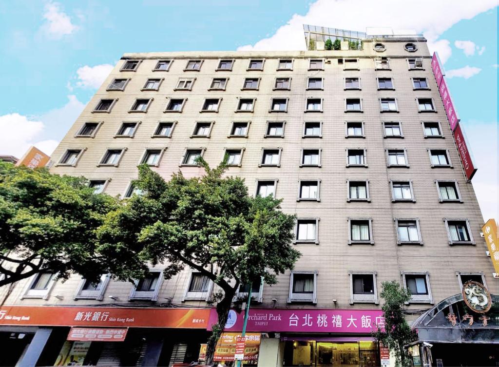 Hotel Orchard Park - Taipei في تايبيه: مبنى ابيض كبير على شارع المدينة