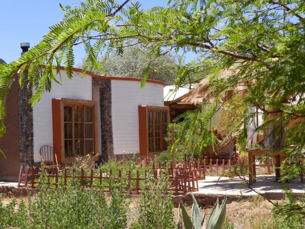 une maison avec une clôture devant elle dans l'établissement Cabaña Media Luna, à San Pedro de Atacama