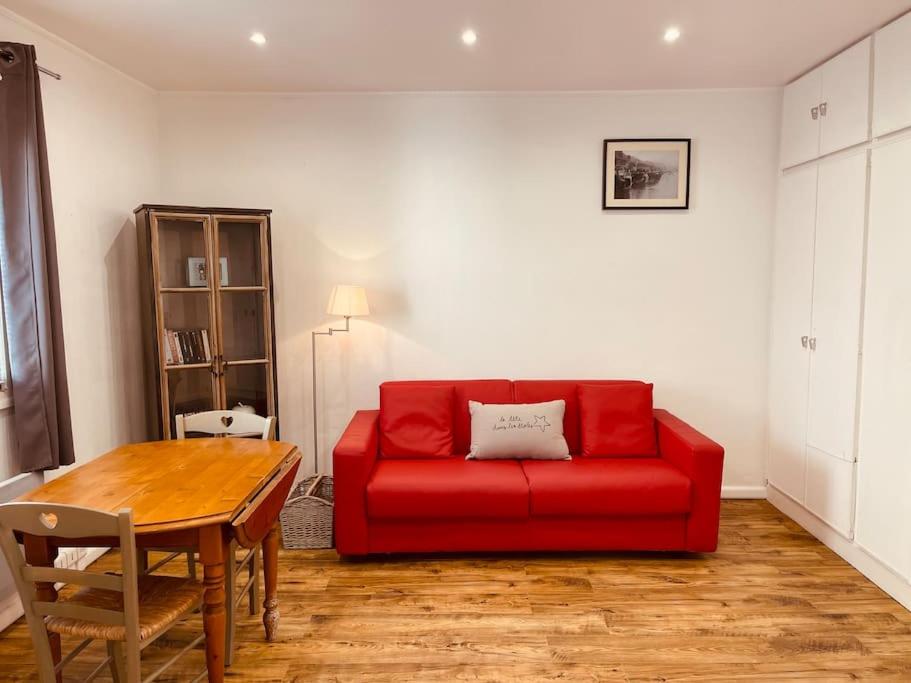 sala de estar con sofá rojo y mesa en Le studio de la mer en Trouville-sur-Mer