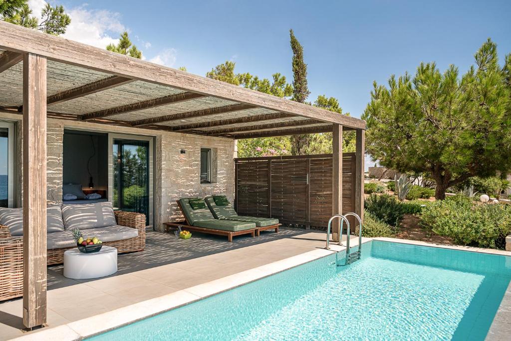 a patio with a swimming pool and a pergola at Kakkos Beach Hotel - Adults Only in Ierapetra