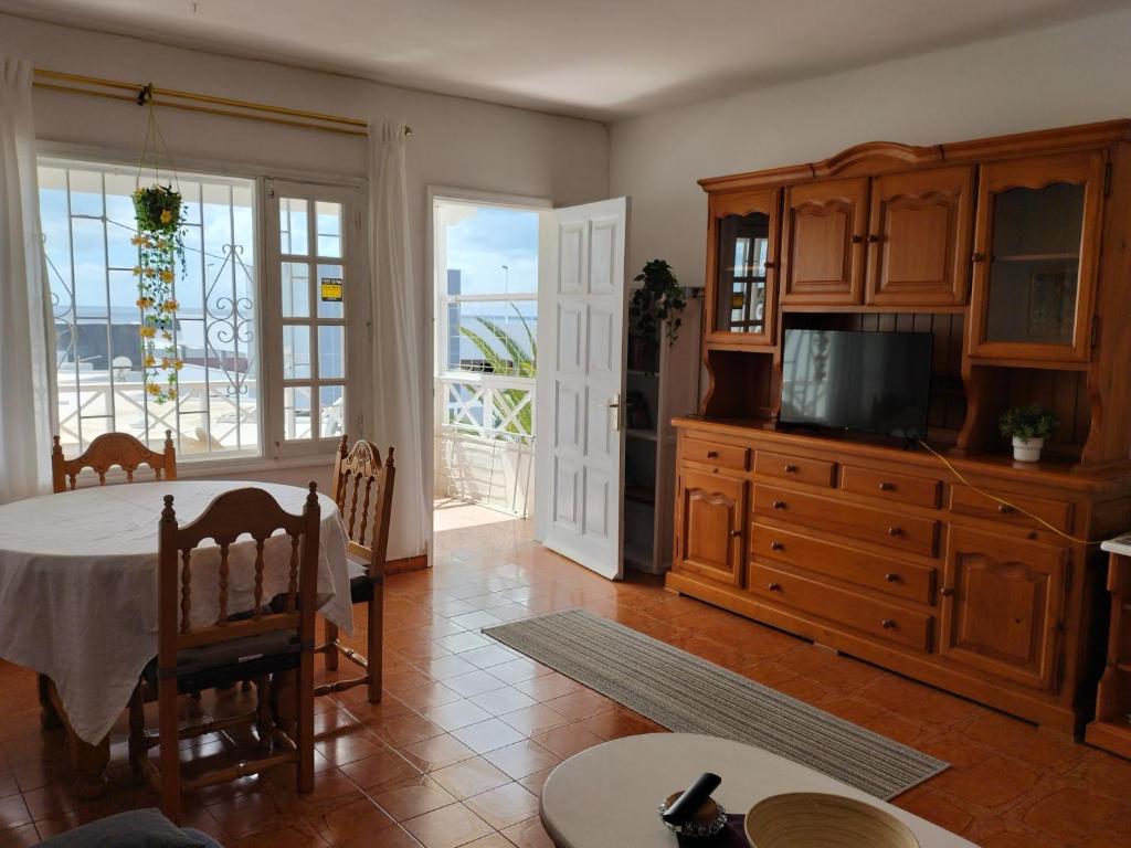 a living room with a table and a tv at Apartamento 2 dormitorios cerca de la playa en Puerto del Carmen in Puerto del Carmen