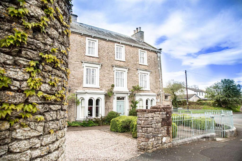 a large brick house with a fence in front of it at Redmayne House in Lake District National Park