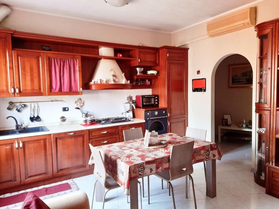 een keuken met houten kasten en een tafel met stoelen bij Casa vacanze “da Mara” in Rho