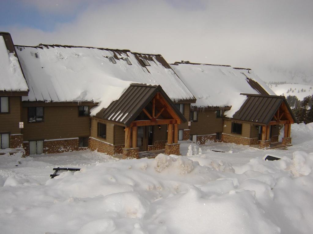a house covered in snow with snow around it at Powder Ridge Village, a VRI resort in Powder Mountain West