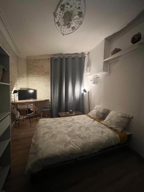 een slaapkamer met een bed en een tafel met een tafel bij Le Bjorn - T1 chaleureux refait à neuf - Centre in Niort