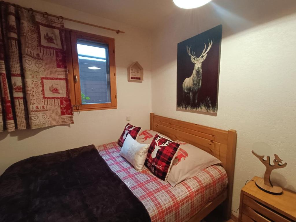 Aigueblanche的住宿－Appartement avec terrasse et parking Privé，卧室配有一张挂着鹿图的床铺。