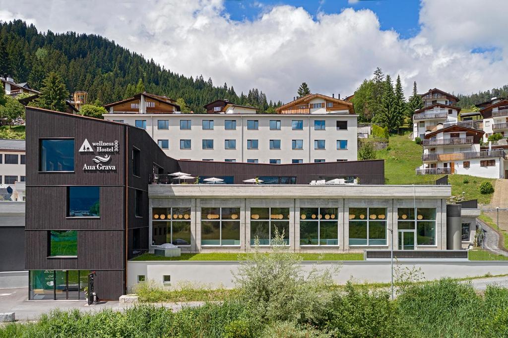 a large building in front of a mountain at wellnessHostel3000 in Laax