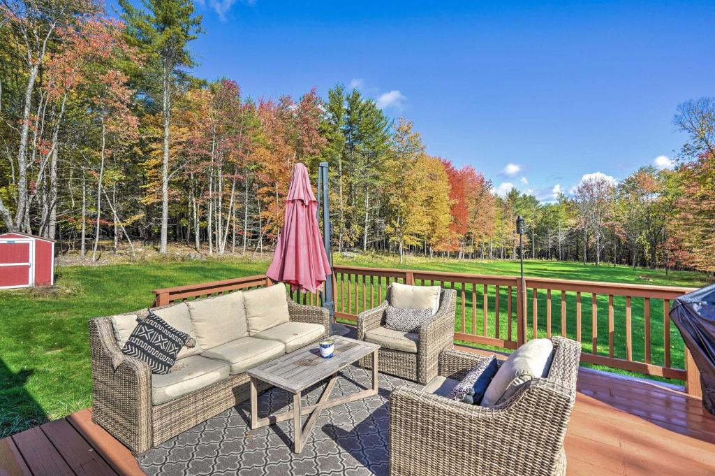 une terrasse avec un canapé, deux chaises et un parasol dans l'établissement Game Room and Spacious Yard 10-Acre Catskills Home!, à East Durham