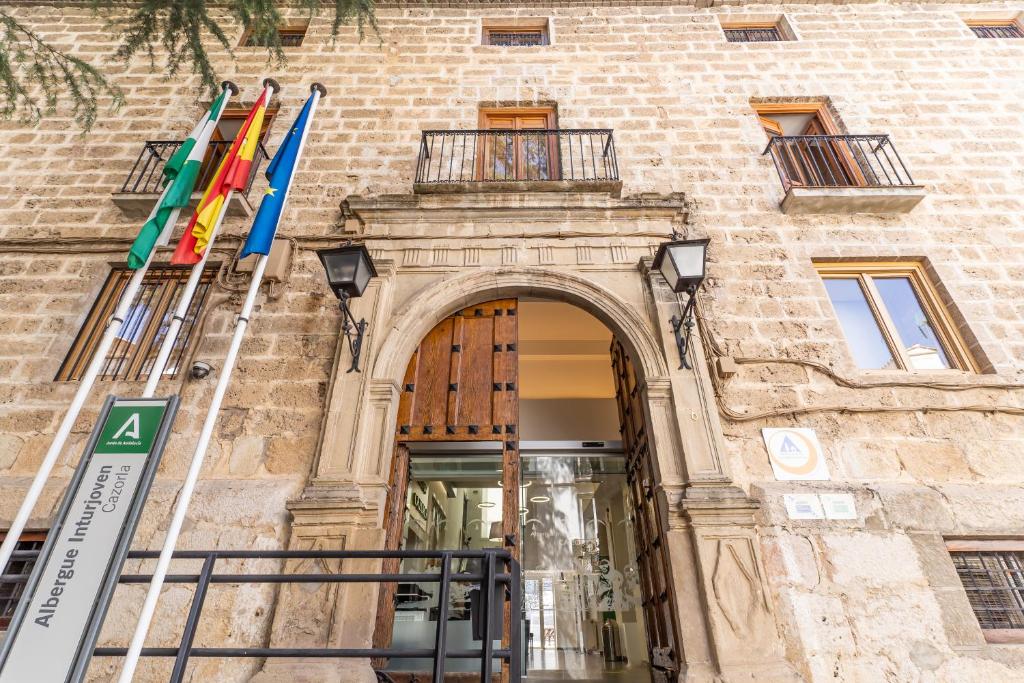 an entrance to a building with flags in front of it at Albergue Inturjoven Cazorla in Cazorla