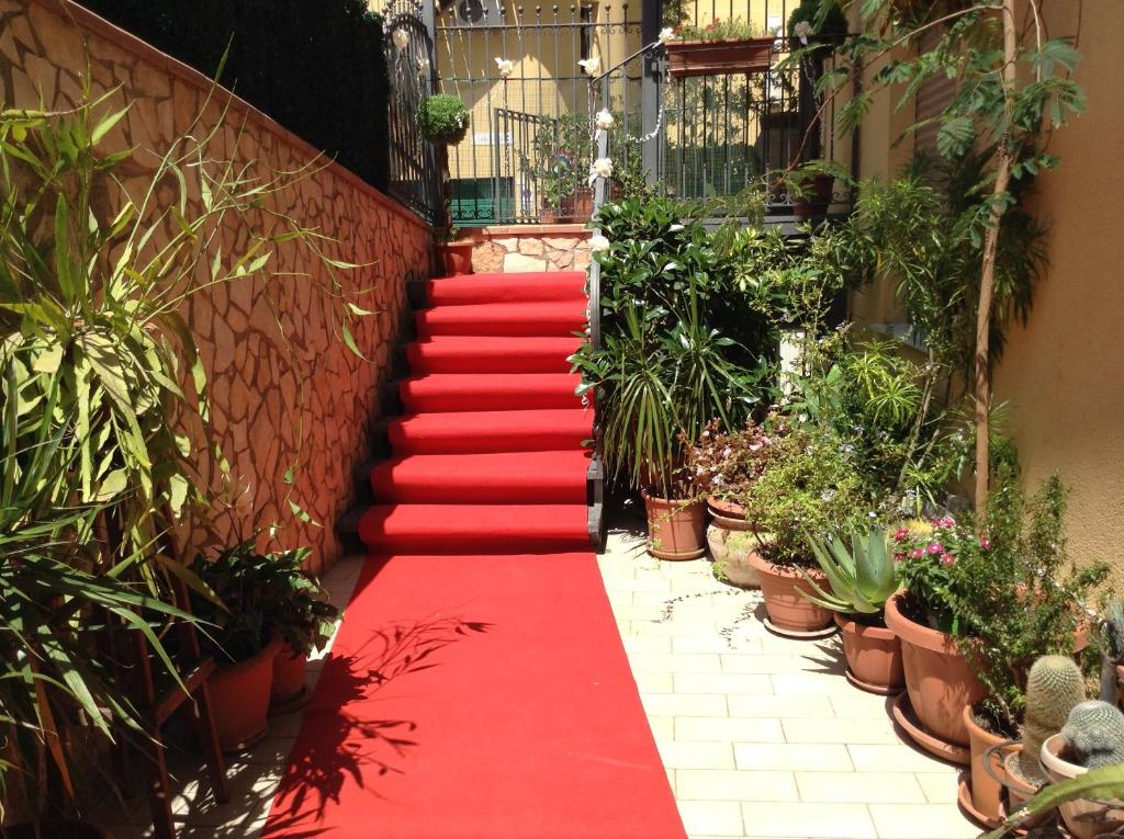 una escalera de moqueta roja con macetas en Il Mandorlo, en Agrigento