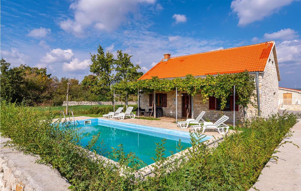 ein Haus mit einem orangenen Dach und einem Pool in der Unterkunft Awesome Home In Biograd Na Moru With House A Panoramic View in Biograd na Moru