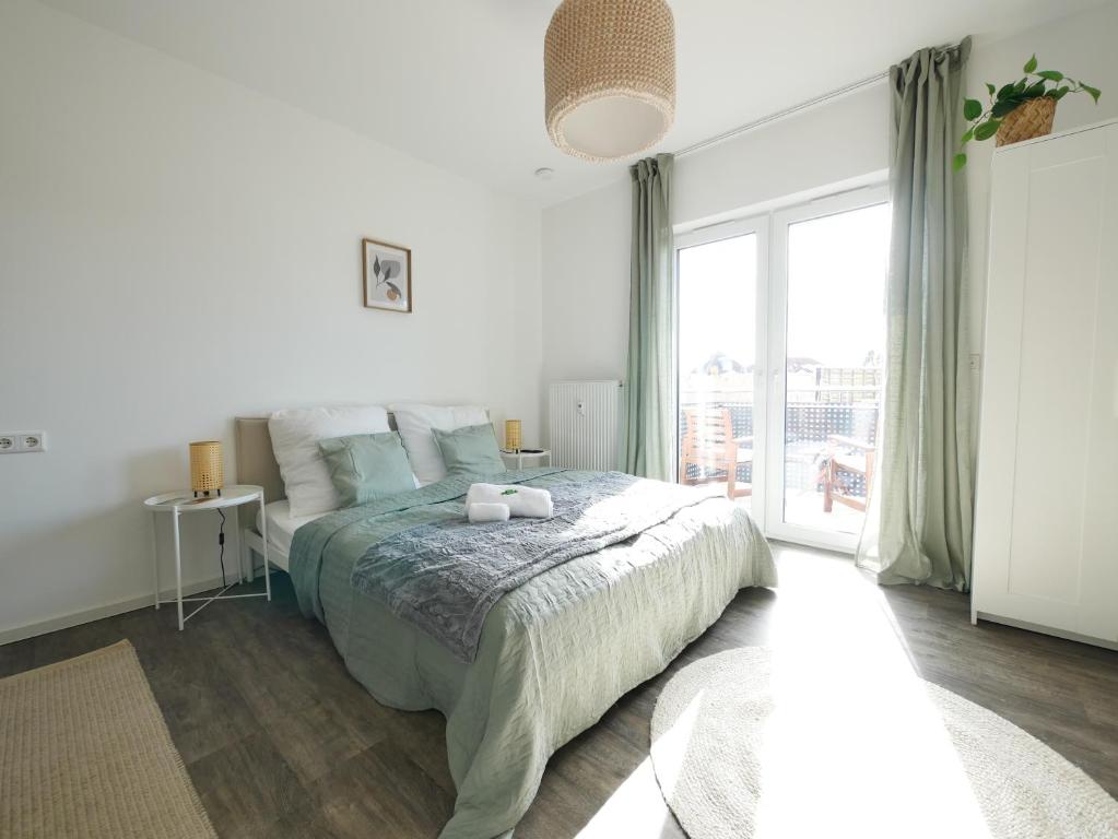 1 dormitorio con cama y ventana grande en Zentral, modern, gemütlich mit Balkon & Parkplatz en Paderborn