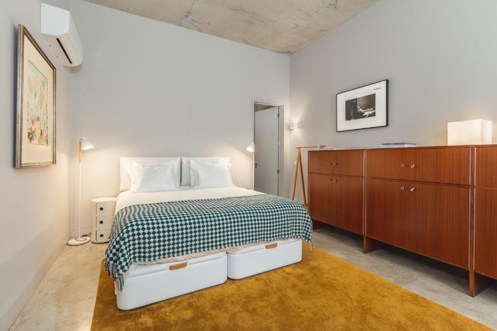 Tanger Suite - Serralves, beach & Yayoi Kusama في بورتو: غرفة نوم مع سرير وخزانة