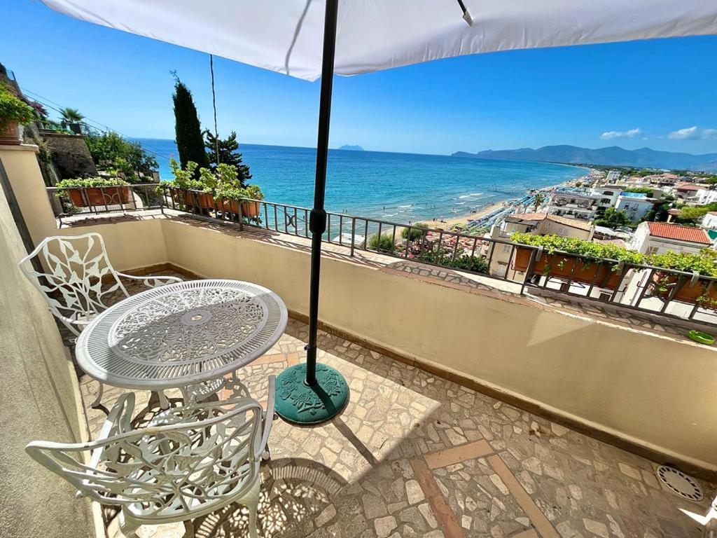 a table and chairs on a balcony with an umbrella at Florenza Residence in Sperlonga
