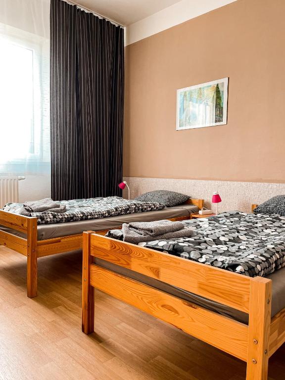 two twin beds in a room with a window at JP ubytování Loštice in Loštice