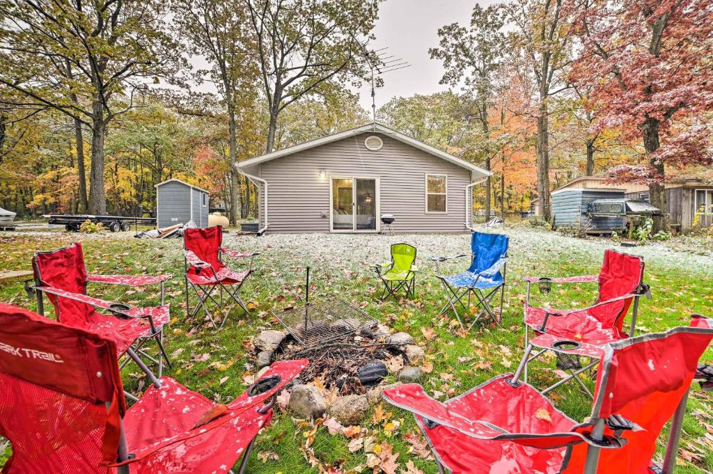 a group of chairs and a fire in front of a house at Dog-Friendly Harrison Retreat with Grill and Fire Pit! in Harrison