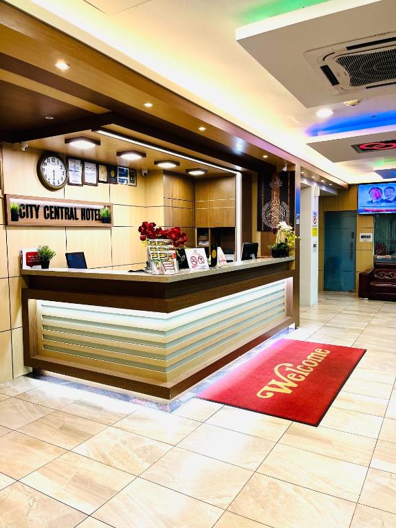 A compact reception lobby with a staffed-looking front desk and city-hotel signage.