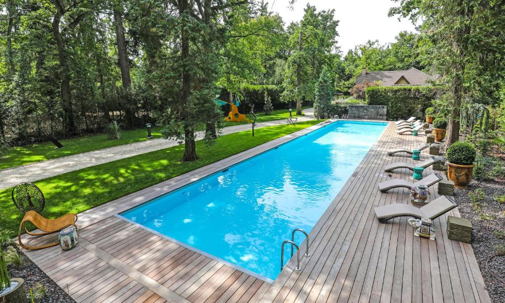 an image of a swimming pool with lounge chairs on a wooden deck at The Iflissen Pavilion - Luxury Villa in Lamorlaye