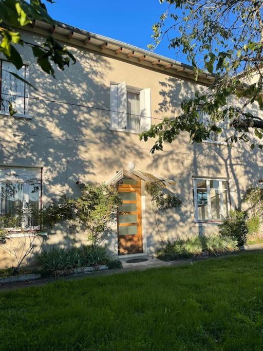 une maison blanche avec une porte et une pelouse dans l'établissement Location maison à Chadron : Haute Loire, à Chadron