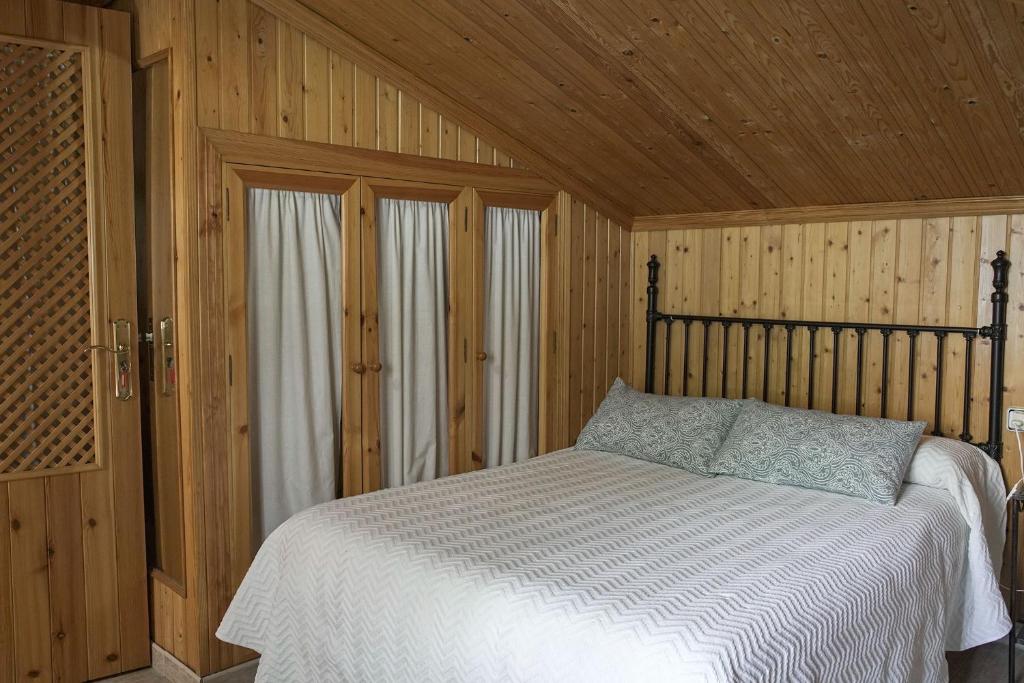 a bedroom with a bed in a wooden room at Casa Rural Las Cuevas de Setenil in Setenil