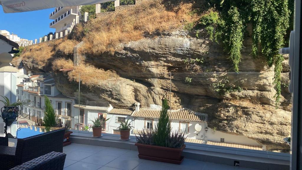 a view from the balcony of a building next to a mountain at Casa Rural Las Cuevas de Setenil in Setenil