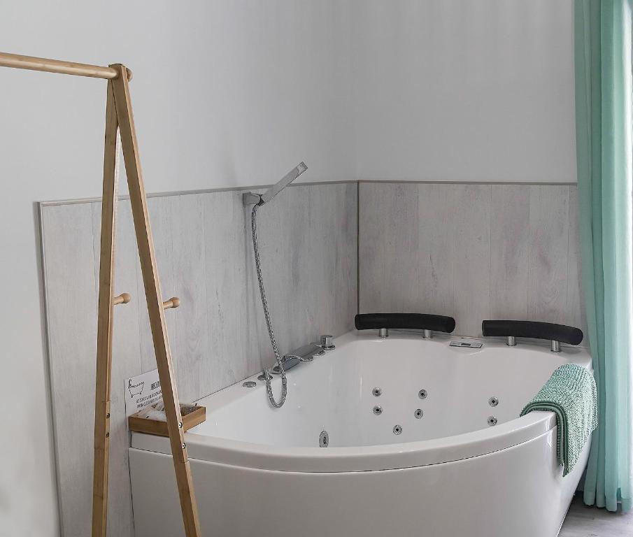 a white bath tub in a bathroom with a shower at Casa Rural Las Cuevas de Setenil in Setenil