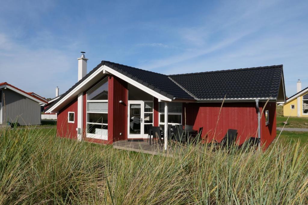 uma casa vermelha com um telhado preto em Resort 2 Sea Lodge C 131 em Grossenbrode