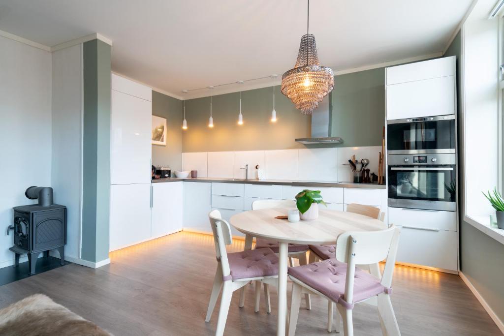 a kitchen and dining room with a table and chairs at The Golden Lion Street Getaway in Trondheim