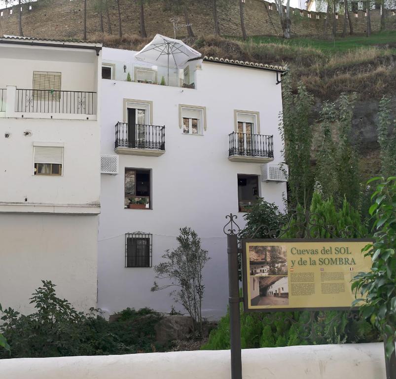 a white building with a sign in front of it at Casa Rural Las Cuevas de Setenil in Setenil