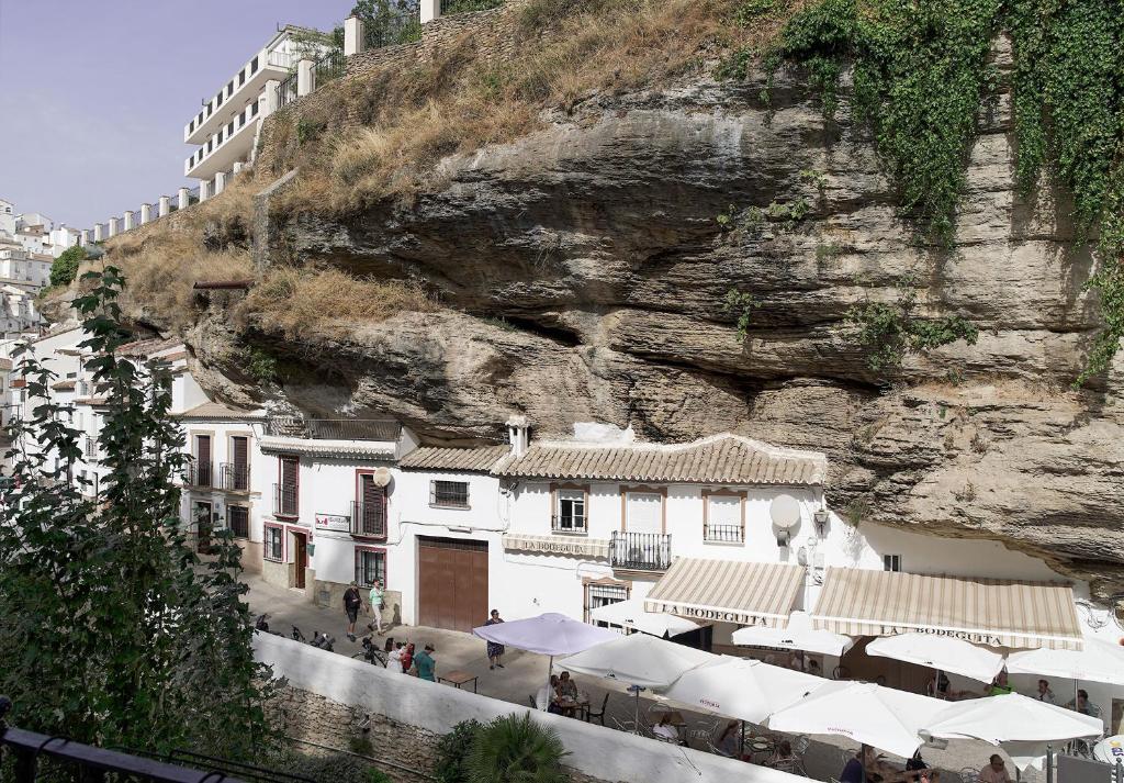 a group of buildings on the side of a mountain at Casa Rural Las Cuevas de Setenil in Setenil
