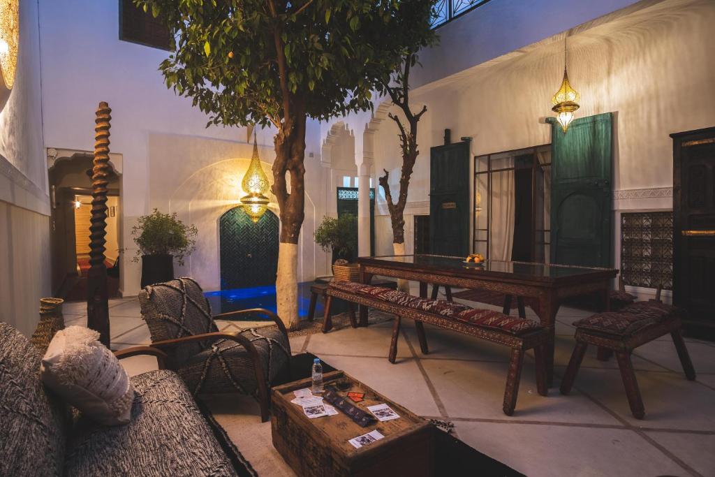 uma sala de estar com mesa e cadeiras em Riad Villa Berna under Swiss Management em Marrakech