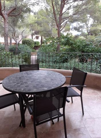 une table noire et des chaises sur une terrasse dans l'établissement RESIDENCE PORTO DI MAR CAVALAIRE, à Cavalaire-sur-Mer