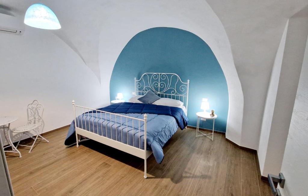 a bedroom with a blue and white bed and a table at LE SEGRETE DEL POZZO in Capurso