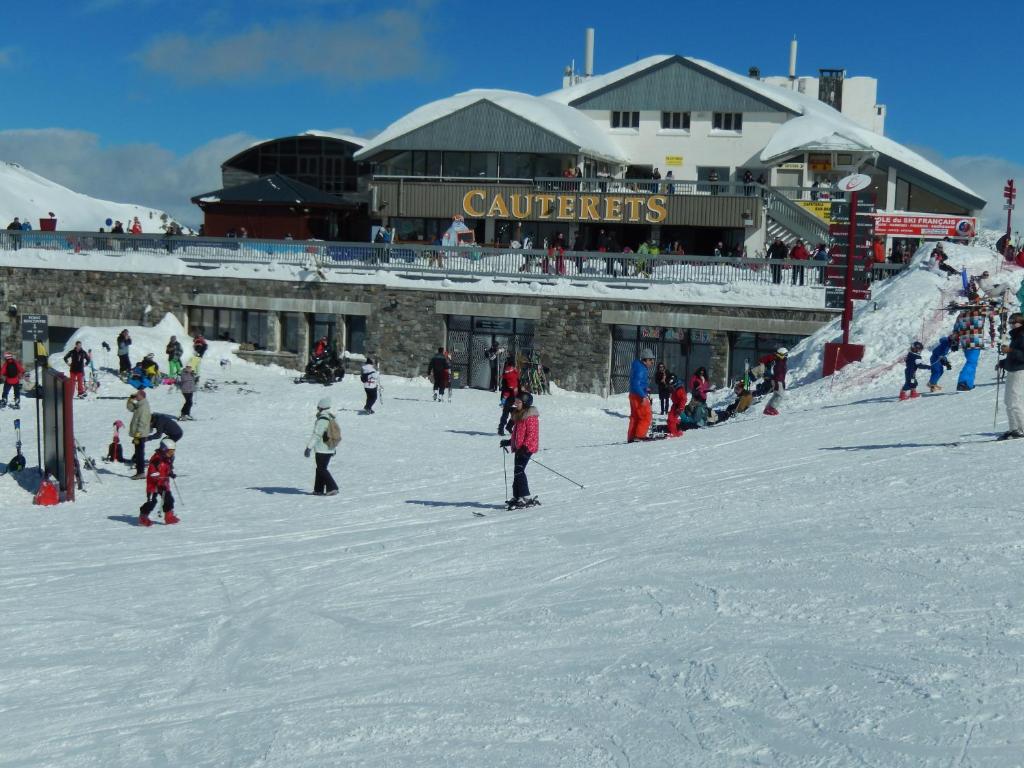 un grupo de personas esquiando en la nieve frente a un lodge de esquí en Le chalet d'estives en Cauterets