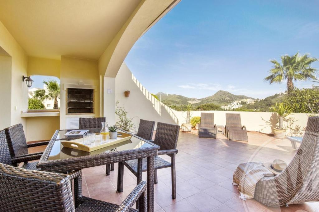 ein Esszimmer mit einem Tisch und Stühlen auf einer Terrasse in der Unterkunft La Manga Club Resort - Los Olivos 43 in Atamaría