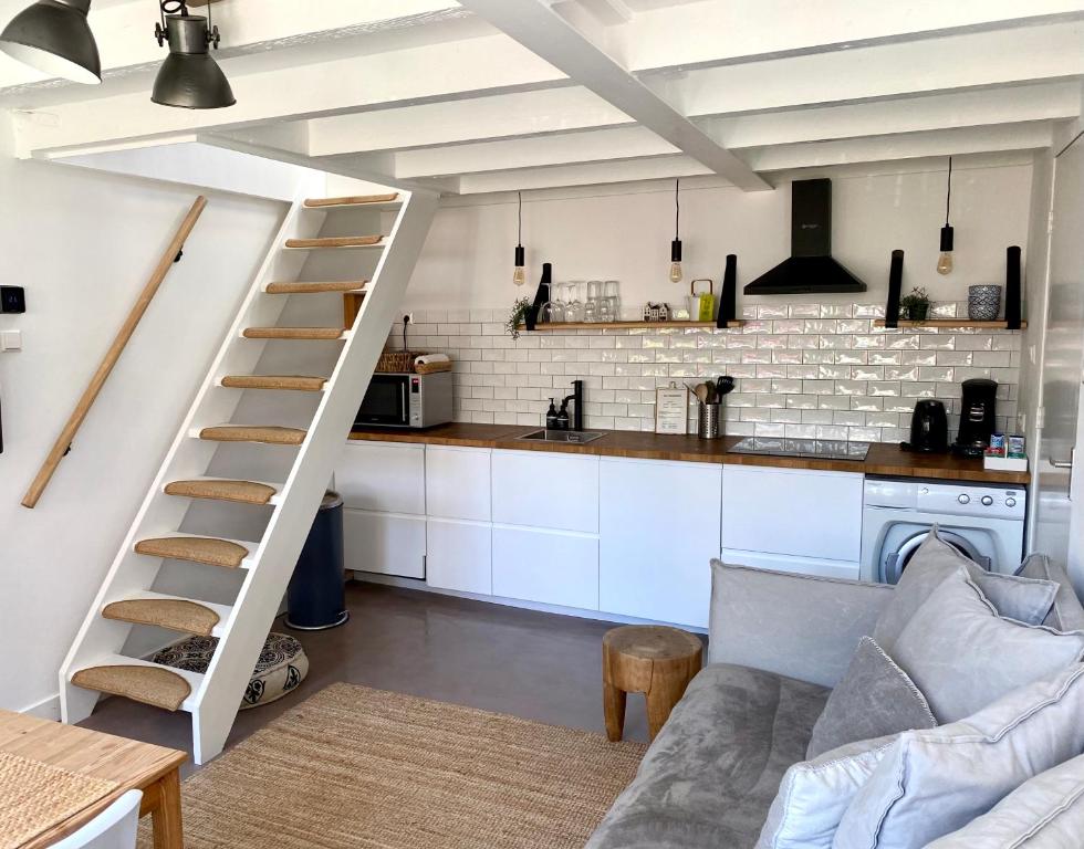 a living room with a ladder and a kitchen at Zilt Noordwijk in Noordwijk aan Zee