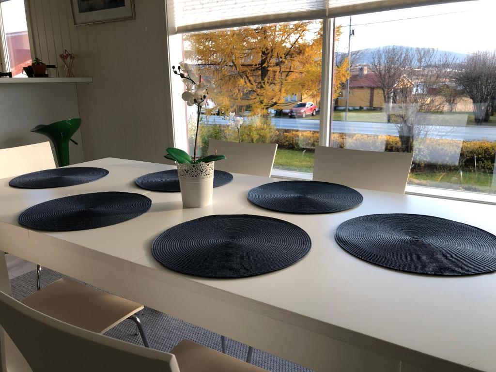 a table with black plates on top of it at Spacious house in Tromsø, perfect for groups of families, tourists or workers in Tromsø