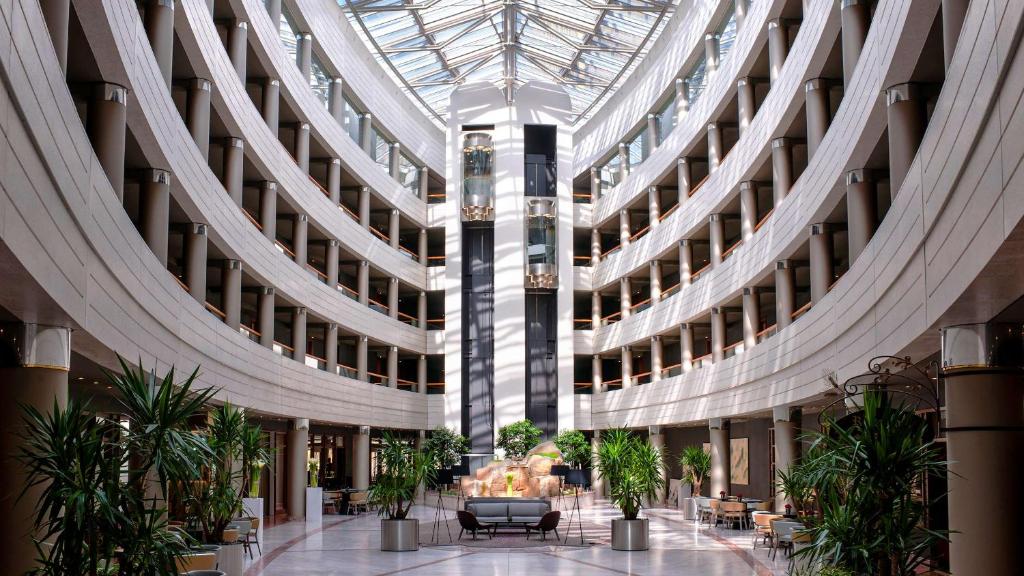 un gran edificio con un vestíbulo con plantas. en Sofitel Luxembourg Europe en Luxemburgo