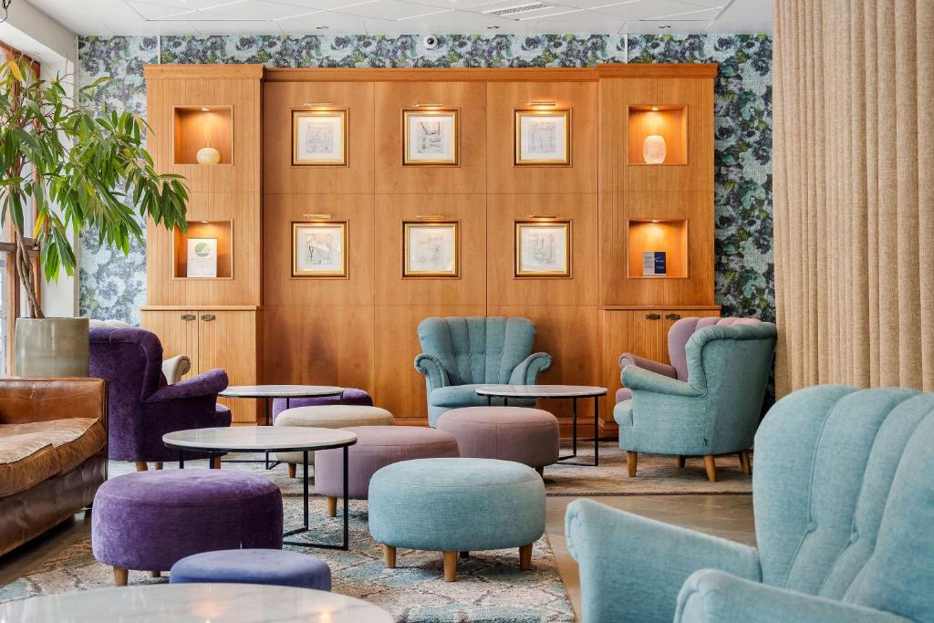 ein Wartezimmer mit blauen und violetten Stühlen und Tischen in der Unterkunft Sure Hotel by Best Western Esplanade in Västerås