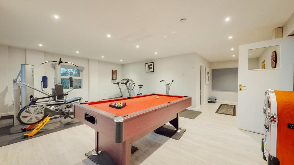 a room with a pool table and a gym at Jaw-Dropping Beach House In Anglesey in Benllech